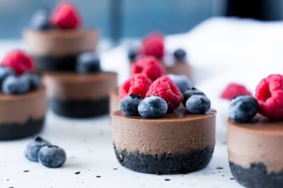 No bake mini vegan chocolate cheesecakes with raspberries and blueberries